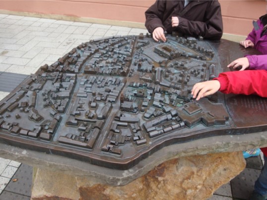 Kinder betasten eine dreidimensionale Oberfläche eines Stadtmodells