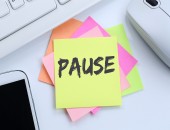 Notizzettel auf einem Schreibtisch mit der Aufschrift: Pause.