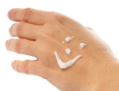Eine Hand mit einem mit Hautcreme gemalten Smiley