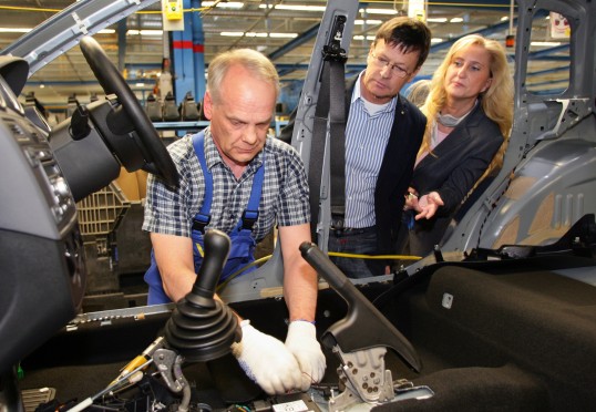 Petra Zink und Dr. Erich Knülle mit einem Mitarbeiter von Ford an einem Rohbau