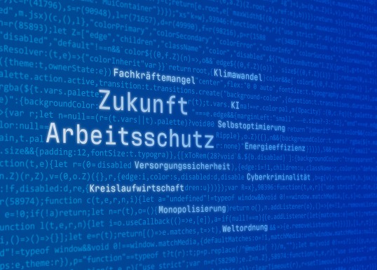 Ein stilisierter blauer Computerbildschirm mit heller Schrift - eine Art Programmcode, in dem Begriffe wie Zukunft, Arbeitsschutz, Fachkräftemangel u. a. unterschiedlich start hervorgehoben sind, sodass sich eine Art Wortwolke ergibt.