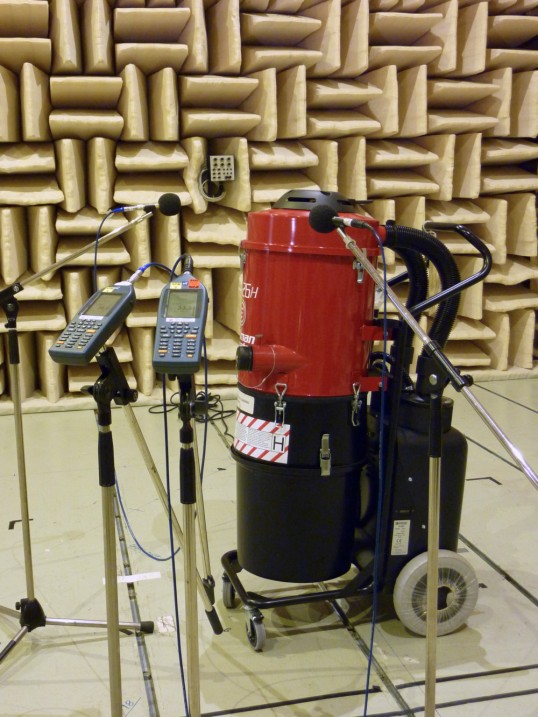 Industrial vacuum cleaner in front ot the sound-attenuating wall