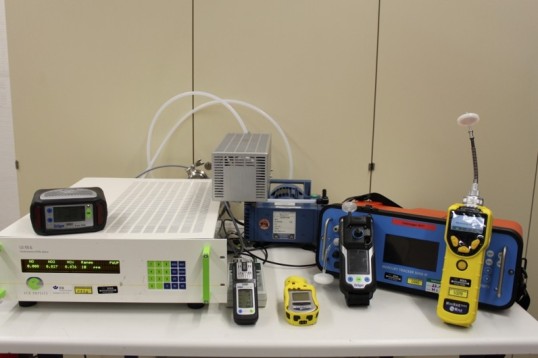 Mehrere direktanzeigende Messgeräte und Prüfgeräte stehen auf einem Labortisch, darunter verschiedene tragbare Gasdetektoren und ein stationäres Analysegerät zur Gefahrstoffmessung.