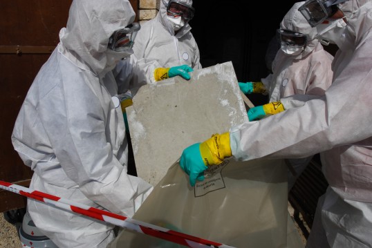 Arbeiter in Schutzausrüstung mit Wandplatten in der Hand