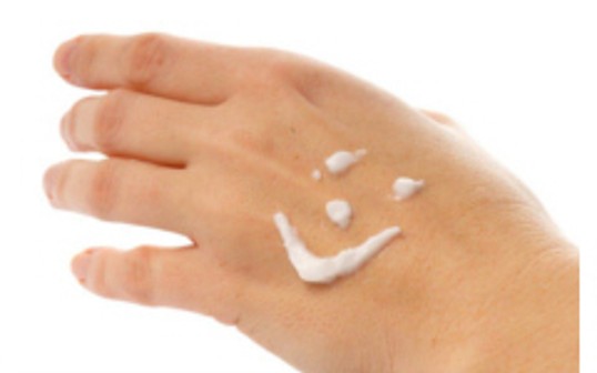 Hand mit Smiley aus Pflegecreme