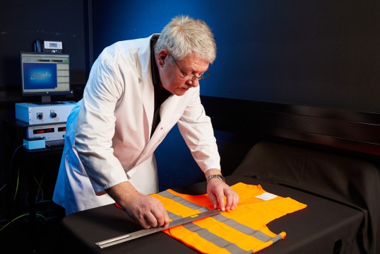 Tester examining the reflective jacket in front of him