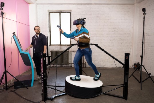 Picture of a Person wearing VR glasses on a treadmill that allows movement in all direction. 