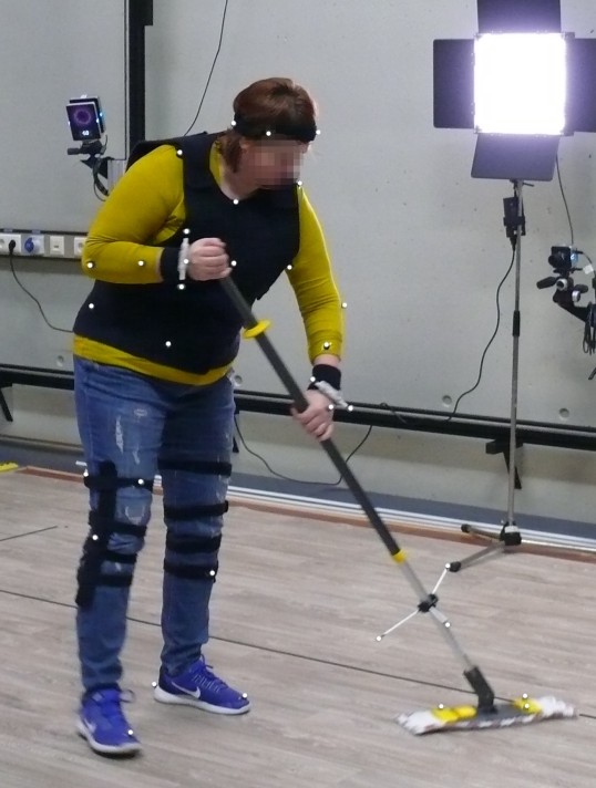 Test person during the laboratory test holding a mop