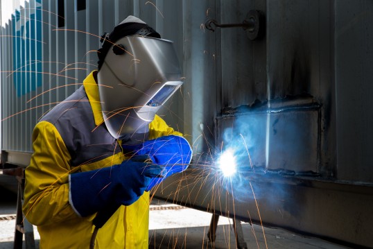 Welder with protective clothes and shield