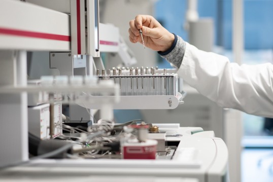 Foto eines Gaschromatograph welcher gerade von einer Person bedient wird