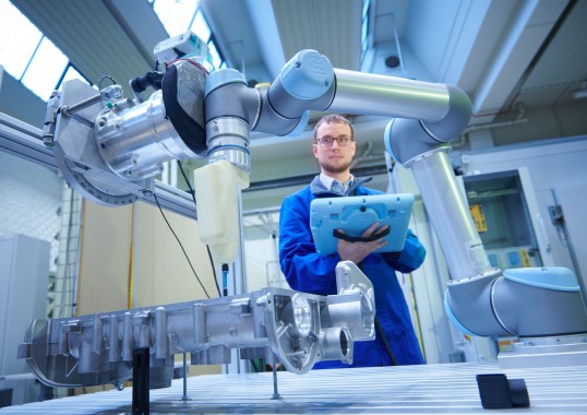 Photo: Man between robots and force measuring device