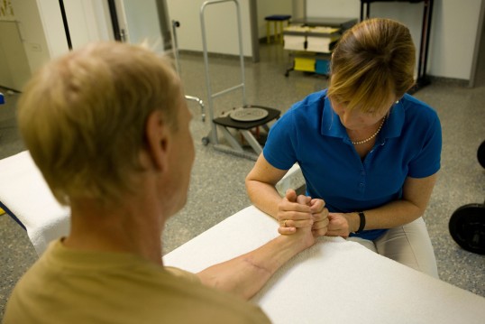 Therapist makes movement exercise with patient