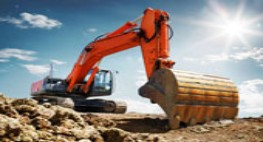 Raupenbagger mit Aushub auf einer Baustelle