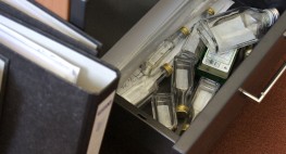 Foto: eine Büro-Schublade mit vielen leeren Schapsflaschen