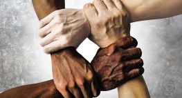 Vier Händen, die sich gegenseitig am Handgelenk berühren und ein Viereck bilden.