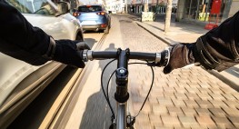 Bild eines Fahrradlenkers, links davon ein eng überholendes Auto.