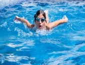 Kind schwimmt im Freibad