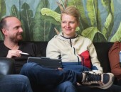 Bild von drei Personen, die zusammen auf einem Sofa sitzen und miteinander sprechen.