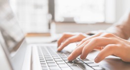 Bild von Händen, die auf einer Tastatur tippen.