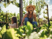 Person sitzt in ihrem Garten, im Hintergrund sitzt ein Kind.