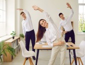 Personen machen in der Pause Dehnübungen.
