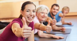 Auf Yogamatten sind fröhliche Personen verschiedener Alters zu sehen.