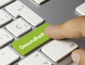 Tastatur mit einer grünen Taste, auf der Gesundheit steht. Ein Finger tippt diese Taste an.