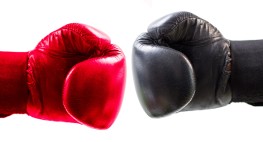 Bild von einem roten und einem schwarzen Boxhandschuh.