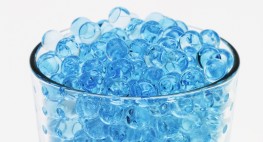 Blaue Glasperlen in einem durchschichten Glas.