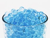 Blaue Glasperlen in einem durchschichten Glas.