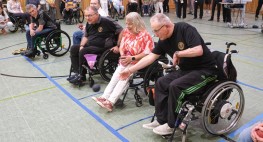 Mehrere Personen im Rollstuhl spielen Hallenboccia in einer Sporthalle.