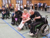 Mehrere Personen im Rollstuhl spielen Hallenboccia in einer Sporthalle.