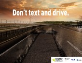 Bild einer Landstraße. Mit weißem Text steht darauf: Don´t text and drive.