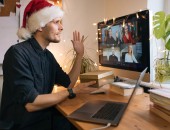 Foto: Mann mit Weihnachtsmann-Mütze in einer Videokonferenz 