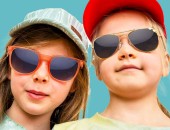 Foto: Nahaufnahme von zwei Kindern mit Sonnenbrille und Mütze