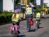 Foto: Ein Erwachsener fährt mit zwei Kindern Fahrrad 