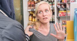 Foto: eine Kassiererin wird von einem Kunden bedroht