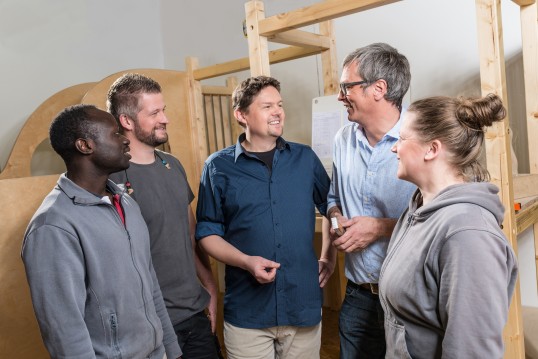 Group of five persons talking to eachother