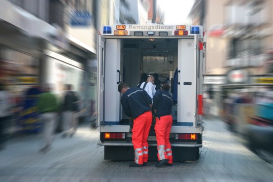 Sanitäter tragen einen Verletzten in den Krankenwagen