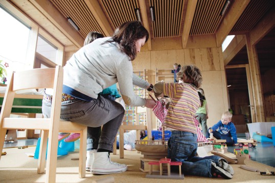 Kingergärtnerin spielt mit Kindern