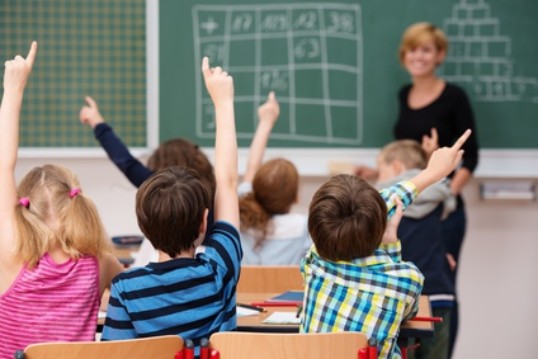 mehrere Schüler melden sich vor der Lehrerin