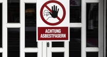Warnschild vor Asbest an einer Eingangstür