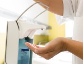 Hand wird unter einen Spender mit Desinfektionsmittel gehalten.