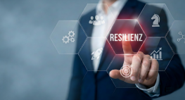 Ein Mann steht hinter einem Zeichenboard und zeigt auf den Begriff Resilienz
