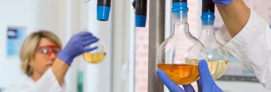 a laboratory employee examines contents of a test tube