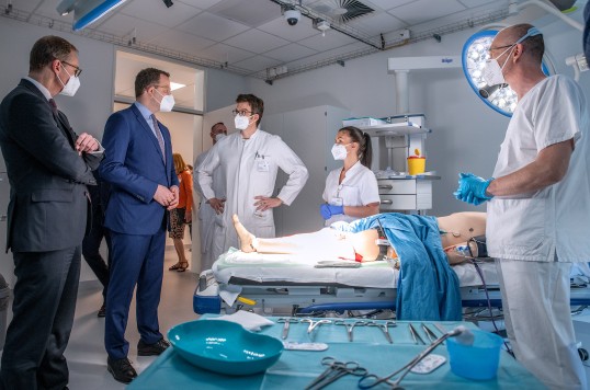 Berlins Regierender Bürgermeister Michael Müller und Gesundheitsminister Jens Spahn im Gespräch mit dem Klinikpersonal am Eröffnungstag zu sehen. Sie befinden sich ein einem sogenannten Schockraum.
