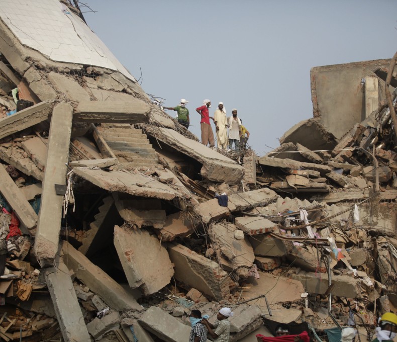 Die eingestürzte Textilfabrik Rana Plaza. Menschen stehen auf den Trümmern. Die eingestürzte Textilfabrik Rana Plaza. Menschen stehen auf den Trümmern.