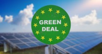 In der Mitte des Bildes steht Green Deal, dahinter sind Solarzellen zu sehen.