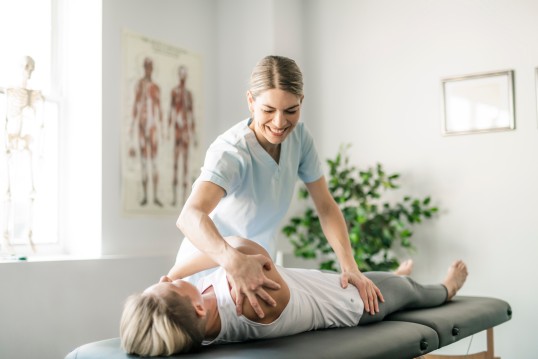 eine Patientin mit Physiotherapeutin bei der Physiotherapie