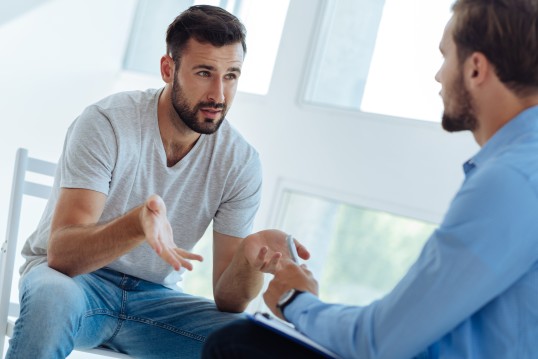 ein Patient spricht mit einem Psychotherapeuten